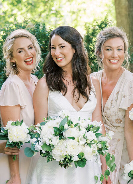 4th of July Wedding: A bride smiling with her bridesmaids on her wedding day.