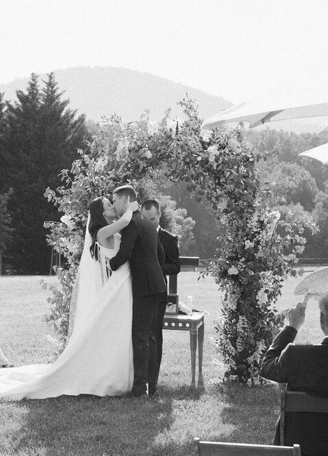 4th of July Wedding: Couple kissing at the alter of their outdoor Virginia wedding ceremony.