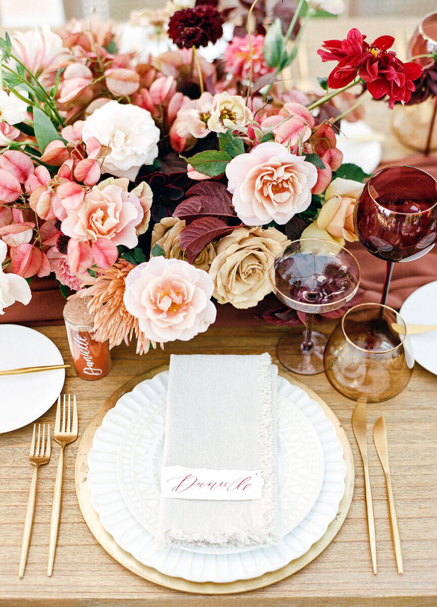 A place setting at an earth tone wedding reception, with a calligraphed place card and spice jar for each guest.