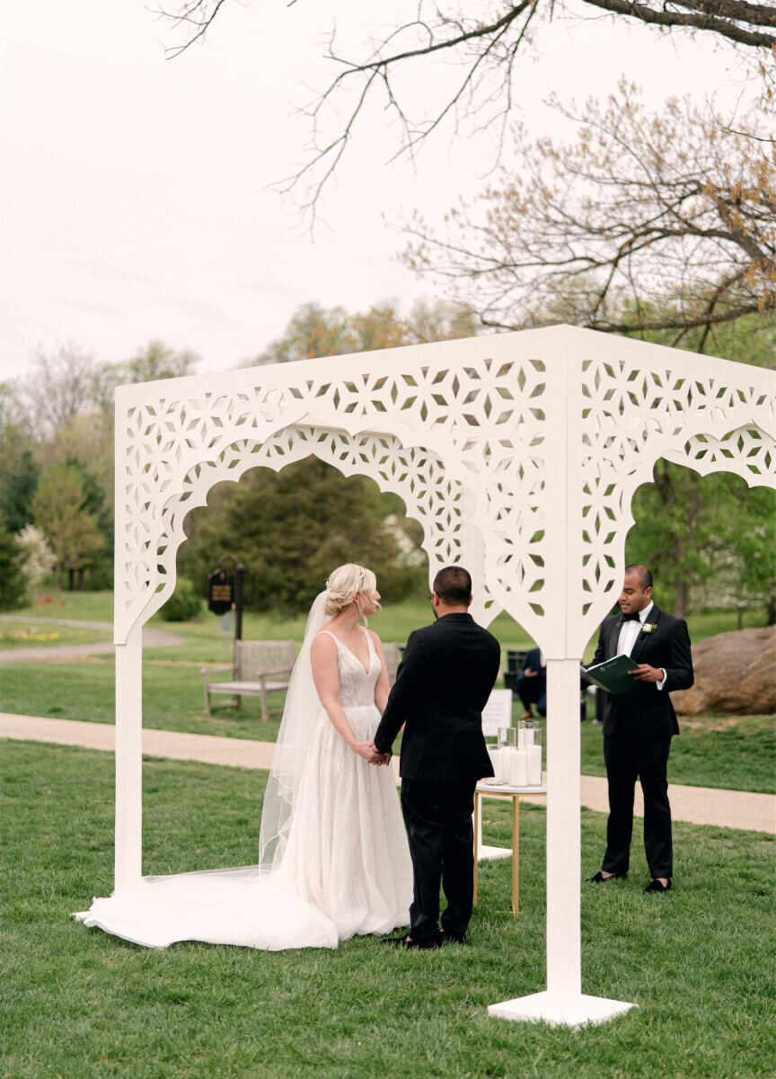 Wedding Traditions: A couple exchanging vows under an ornate pergola.
