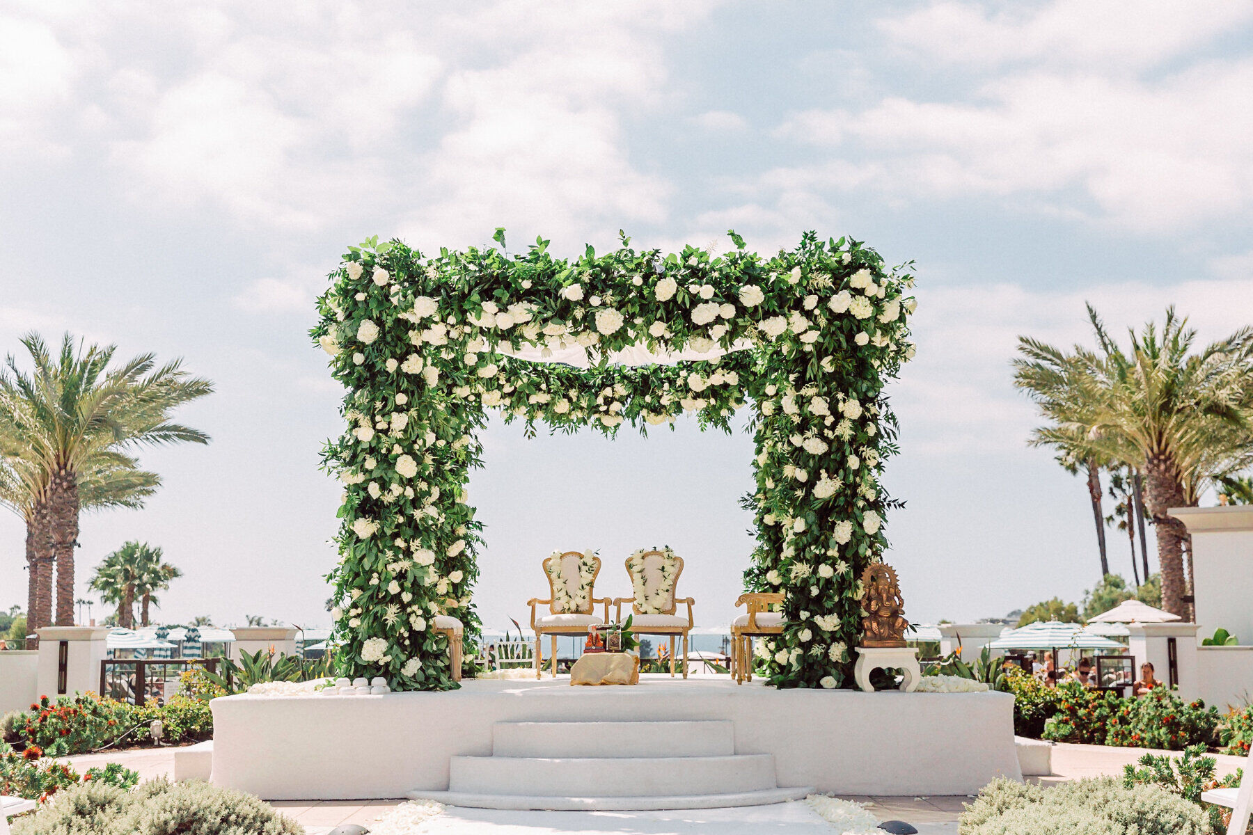 Wedding Traditions: A flower-filled pergola with two chairs in the center.