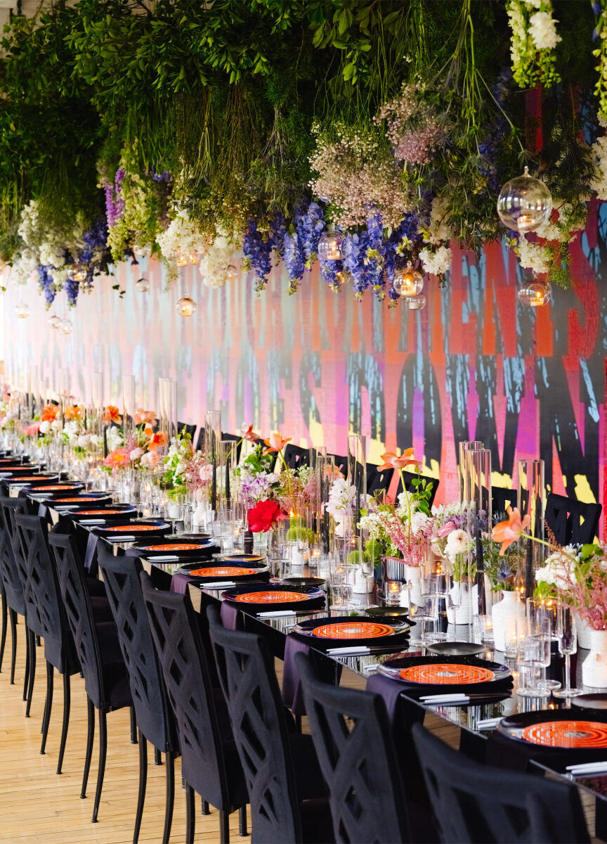 A colorful piece of art anchored the reception space at an art museum wedding, where one long table ran parallel to the long wall.