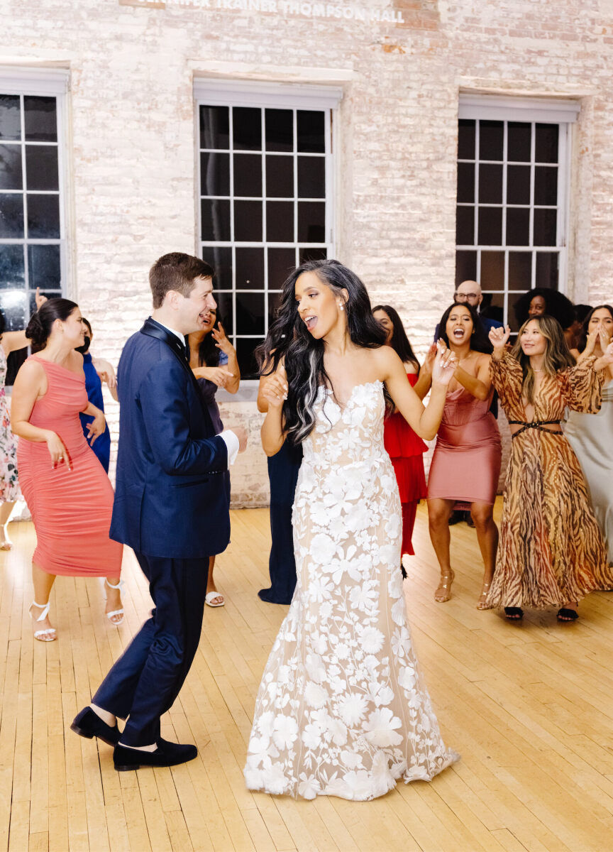 A happy groom and bride, surrounded by their loved ones, dance the night away during their art museum wedding.