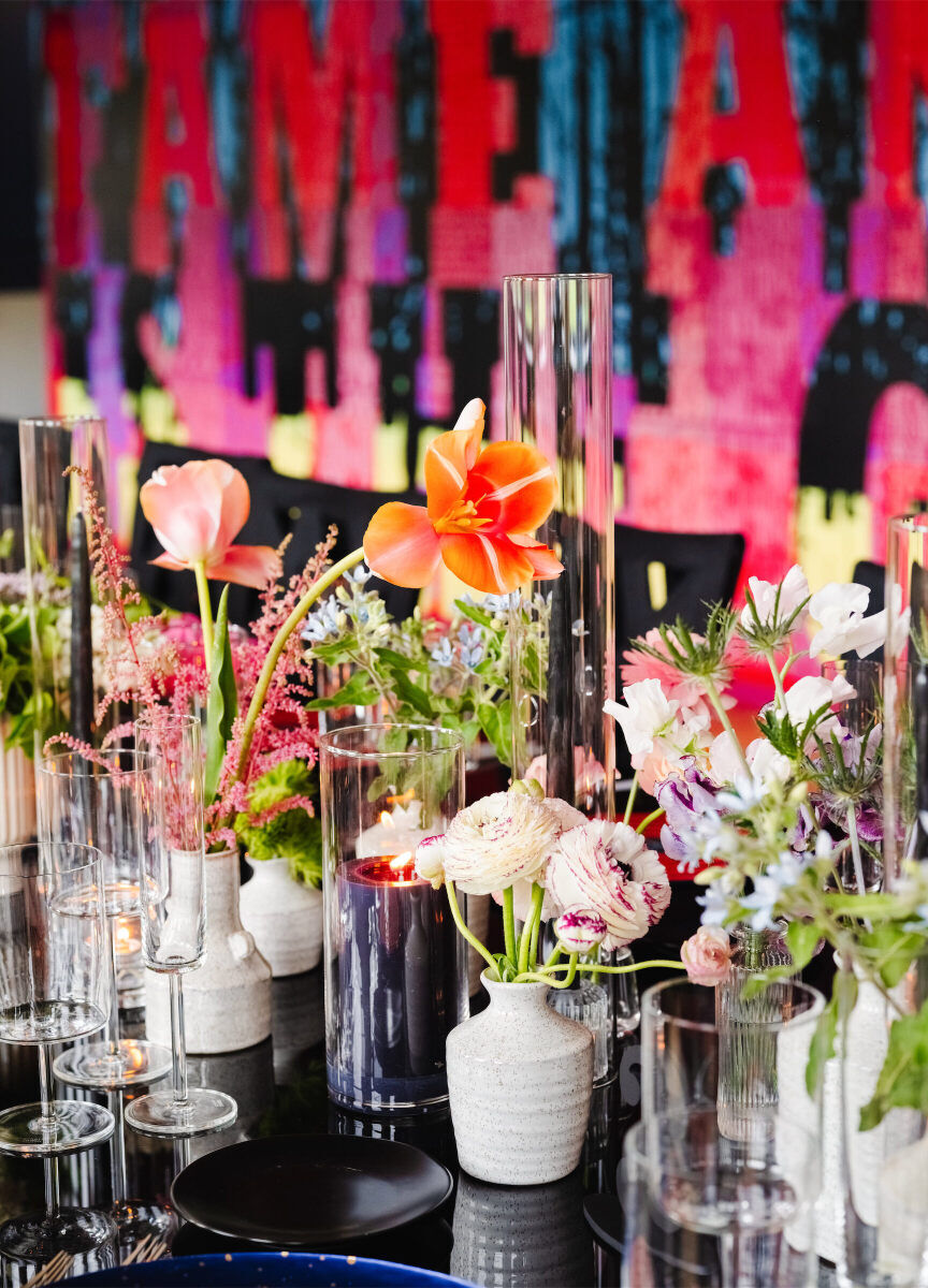 Clusters of small floral arrangements dotted the long table of an art museum wedding, which was designed with an abundance of color.