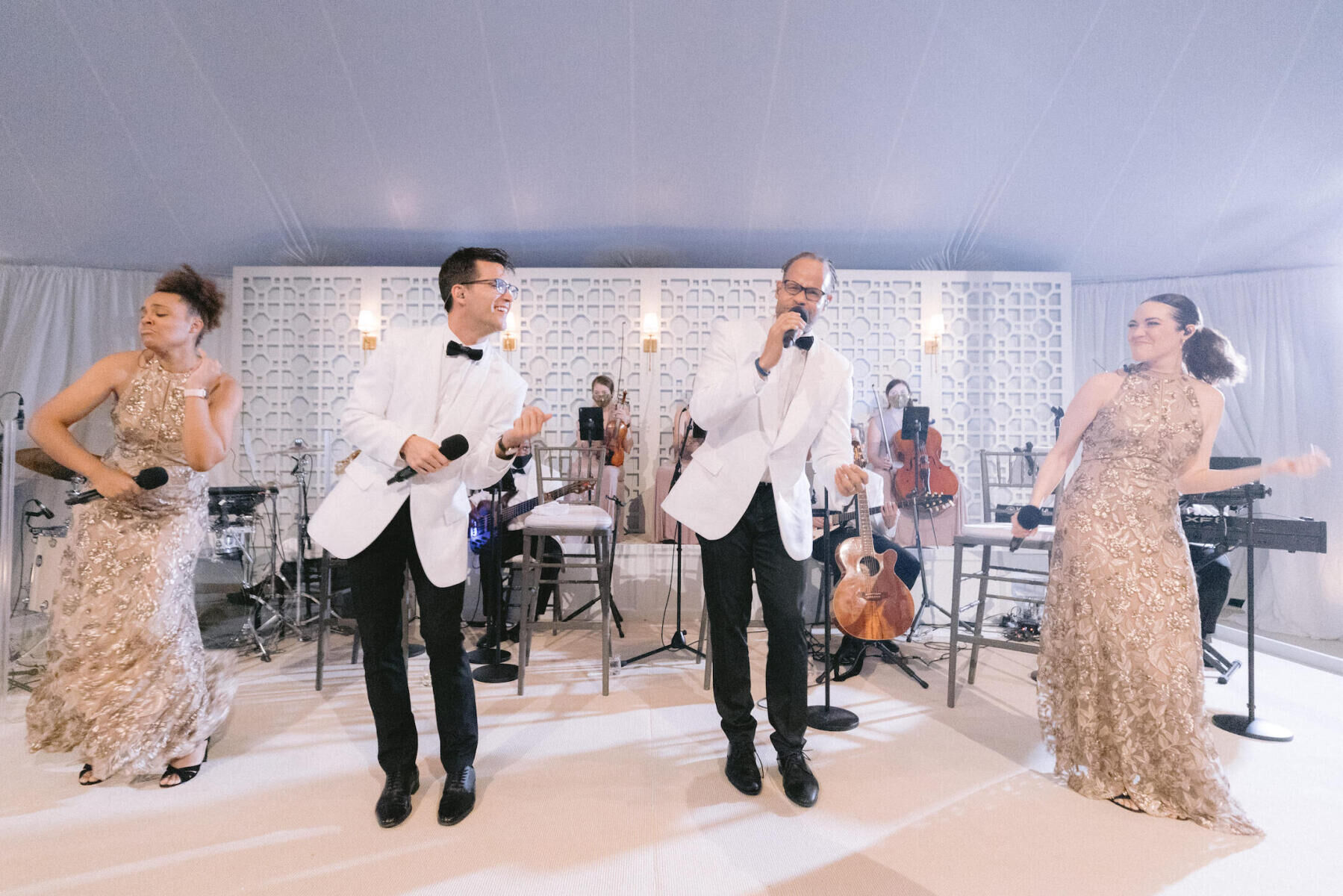A band performs in a tent during an at-home wedding.
