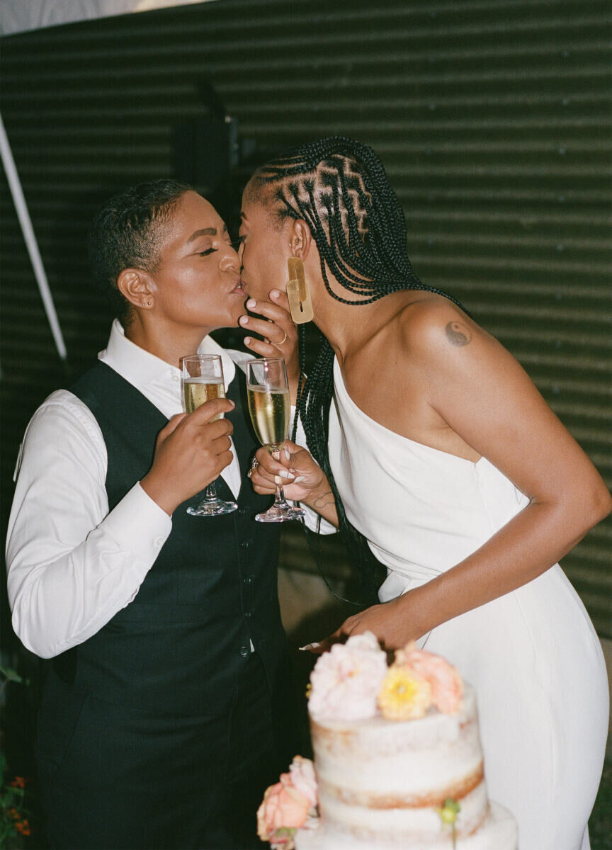 After cutting their cake and toasting with champagne, these brides share a kiss towards the end of their authentic modern wedding reception.