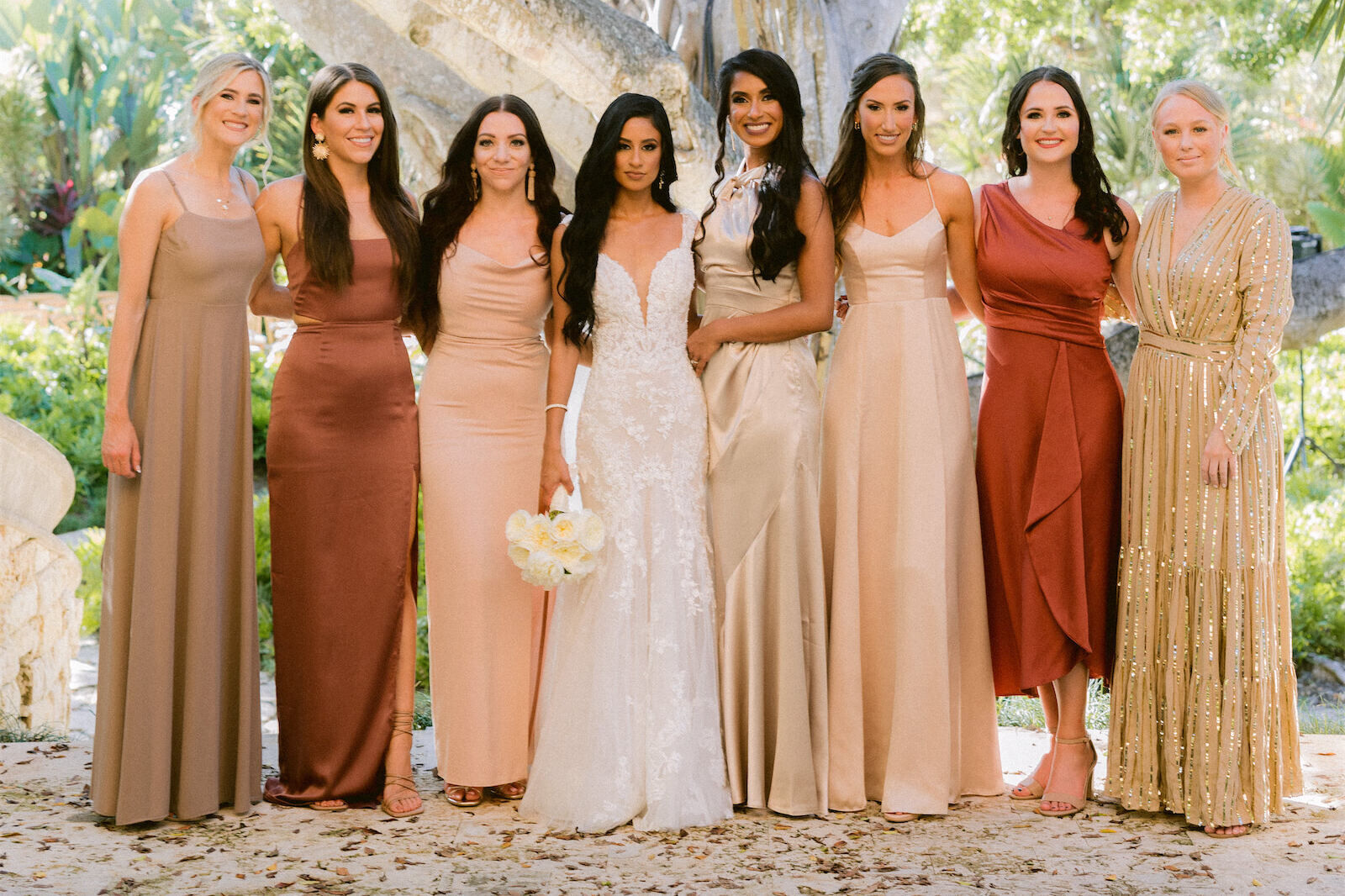 Wedding bride and her bridesmaids wearing earth-toned silk gowns