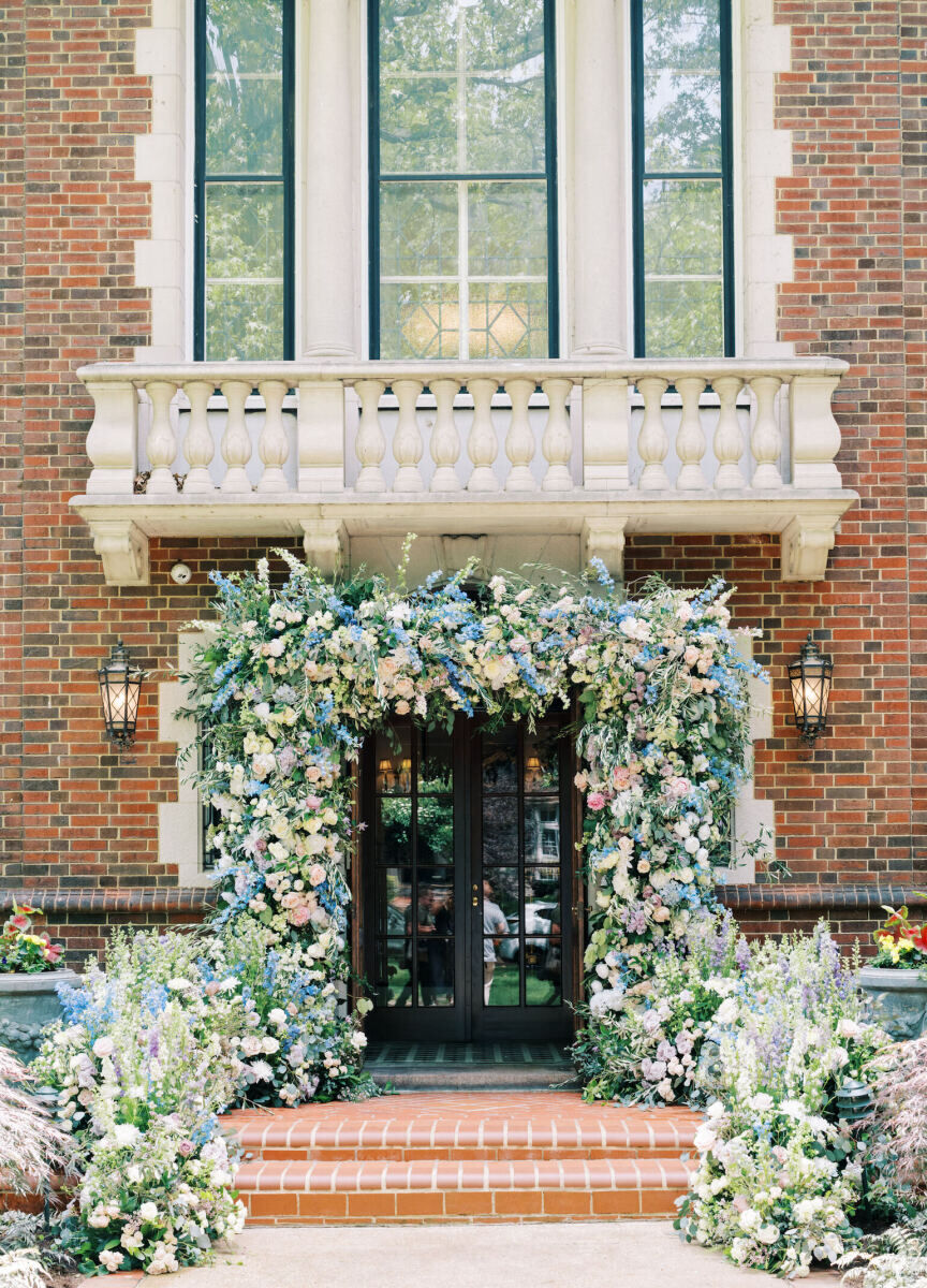 A pastel floral installation at the front entrance of a Missouri house sets the scene for their at-home wedding.