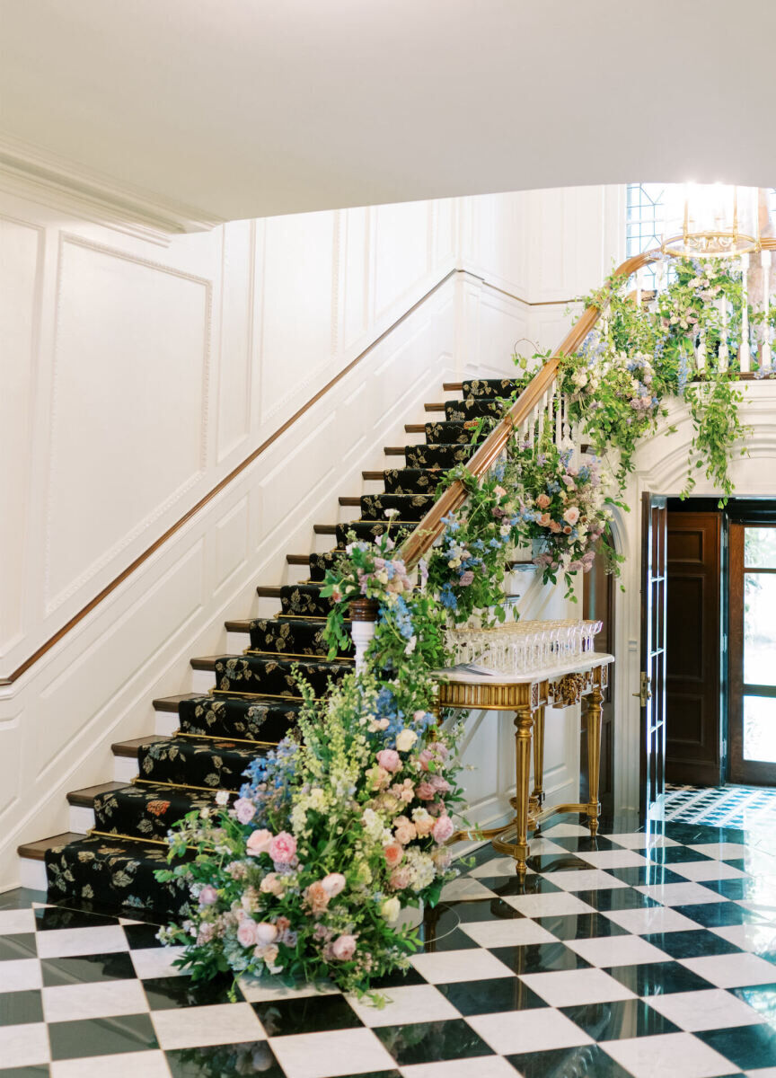 A pastel floral installation on the main staircase of a historic home.