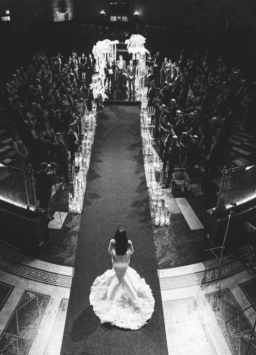 Ballroom wedding details: A bride pauses at the top of the ceremony aisle of her ballroom wedding.