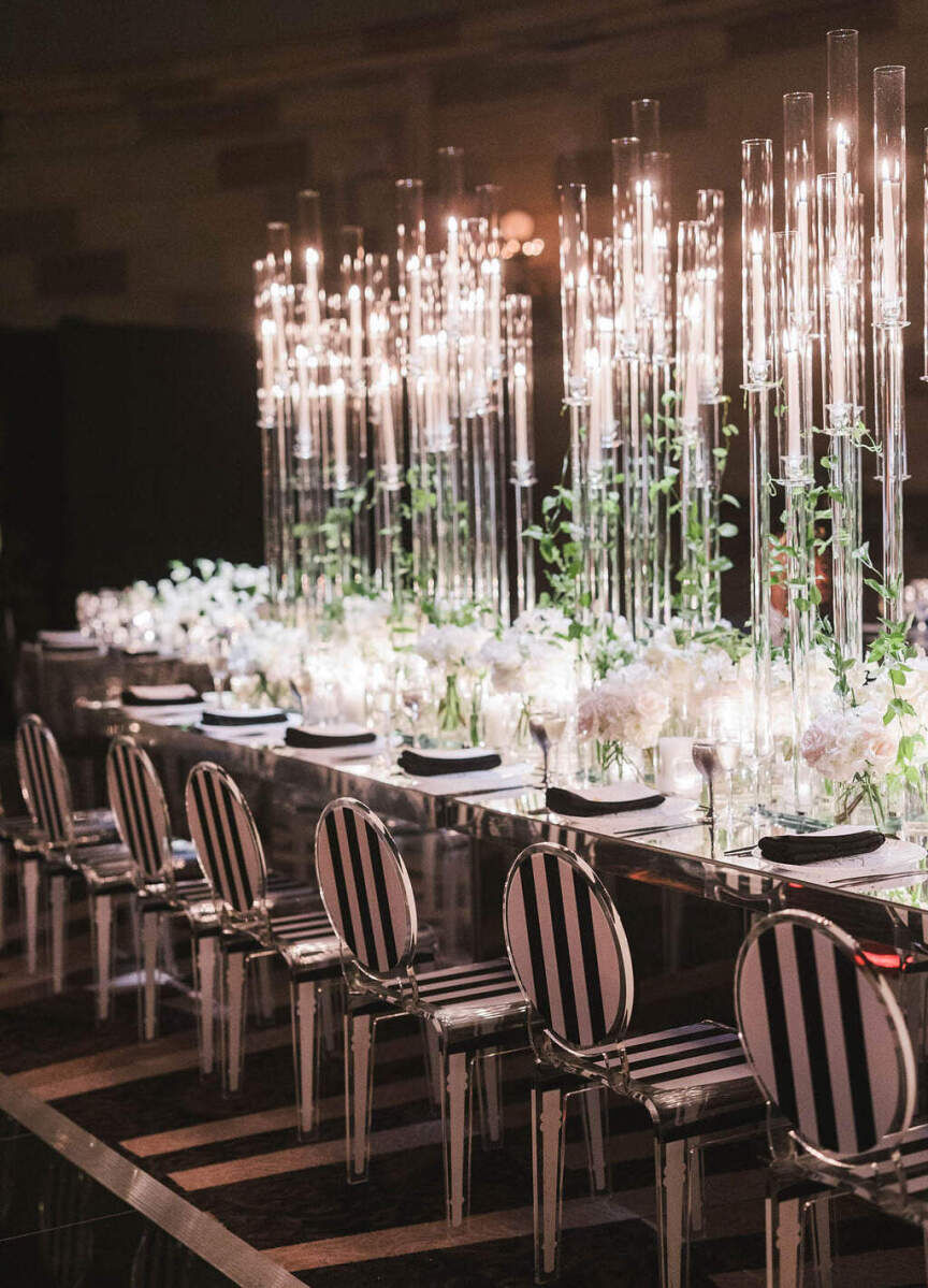 Ballroom wedding details: A modern, glam reception table set with black and white striped chairs and tall candleabras.