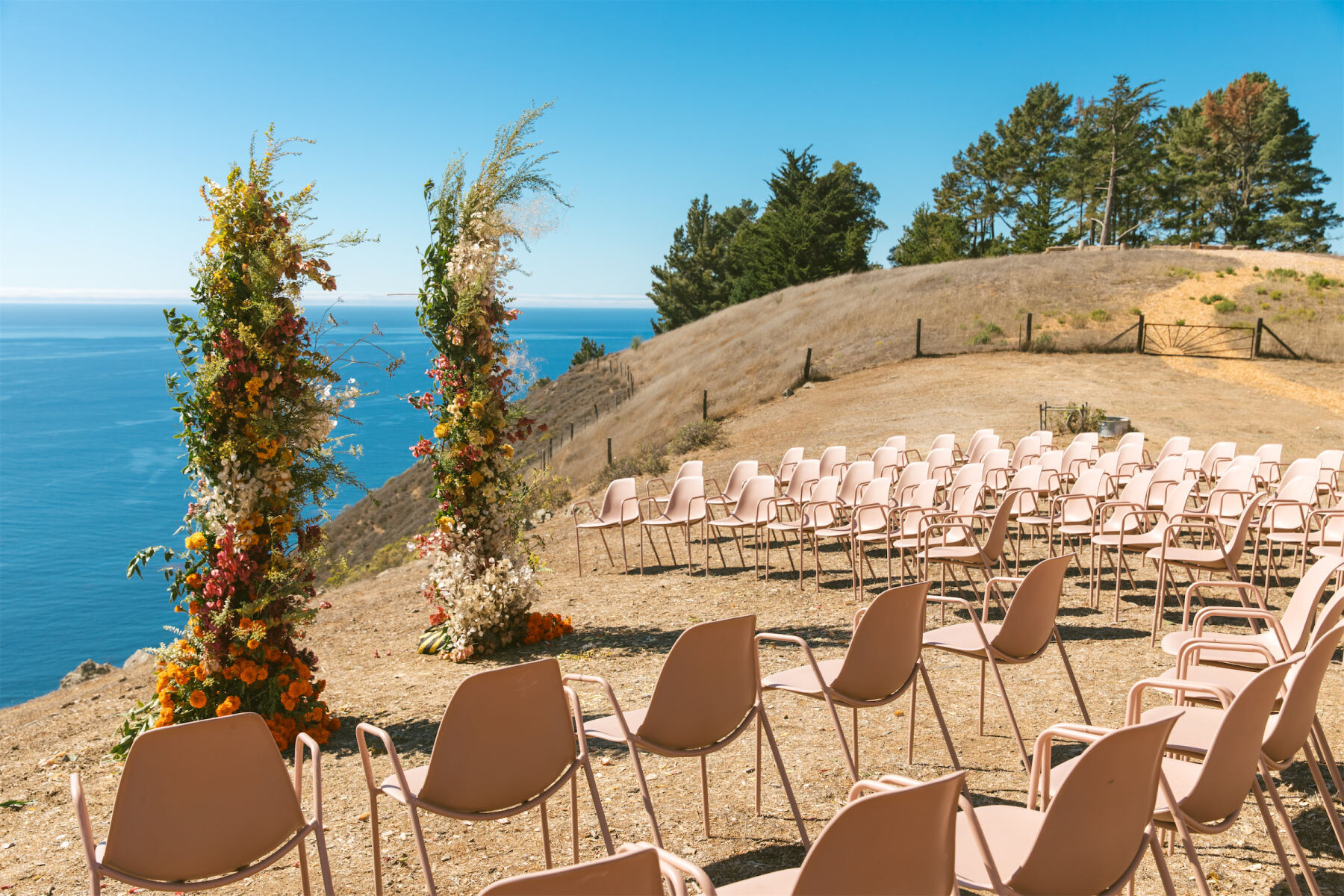 A waterfront Big Sur wedding had the ocean as the backdrop, and modern, blush pink chairs set in a semi-circular arrangement around where the couple would stand.