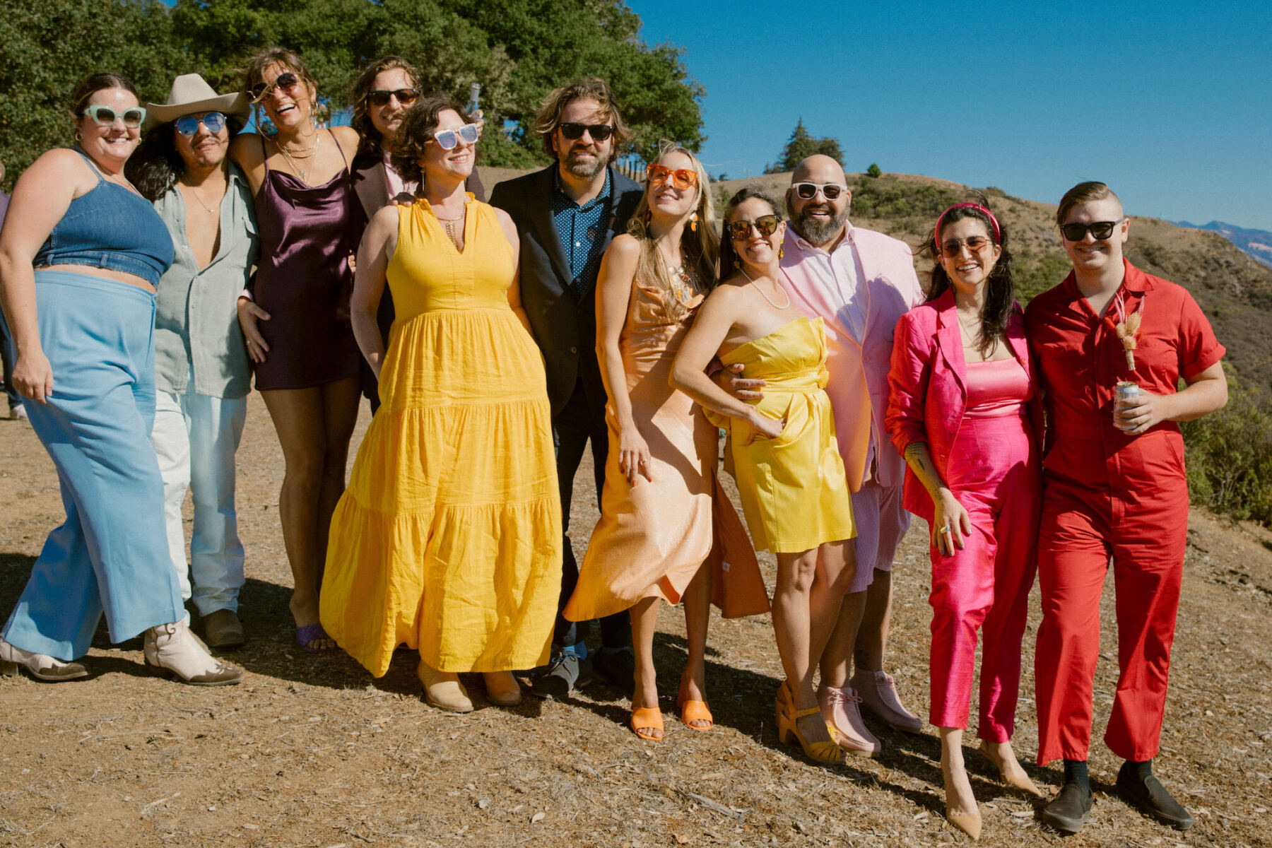 Guests at a Big Sur wedding were asked to wear colorful monochromatic attire. Here, a group of attendees in their bold hues.