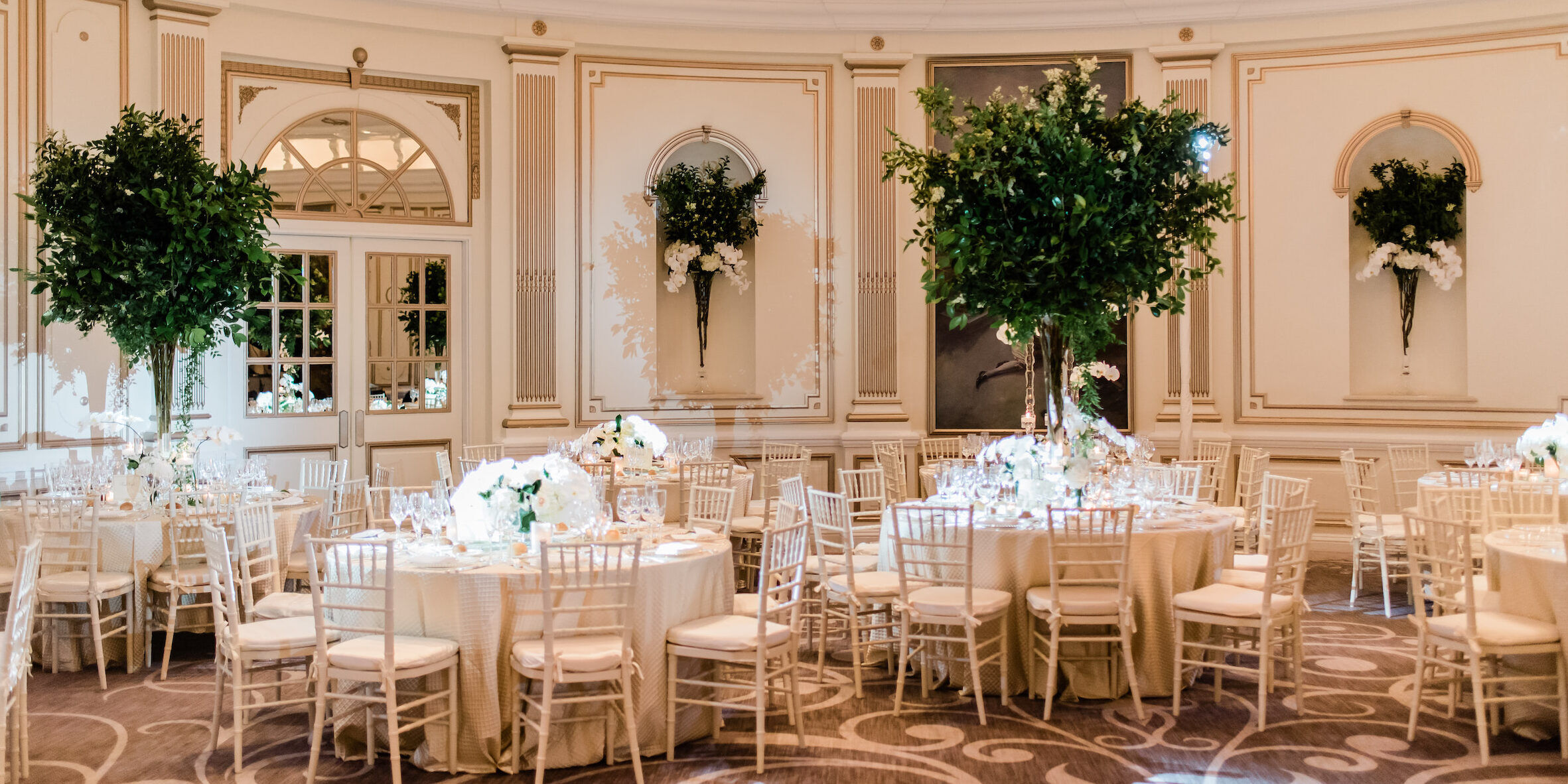 Bright, light wedding reception set up in the ballroom of the Lotte New York Palace