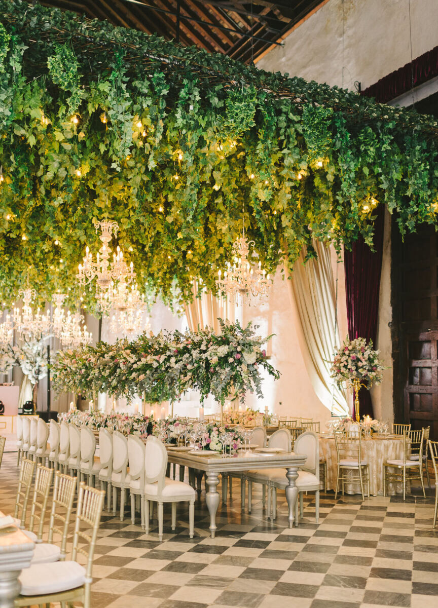 Ceiling Wedding Decor: An elaborate green hanging installation with lights above an indoor-outdoor reception area.