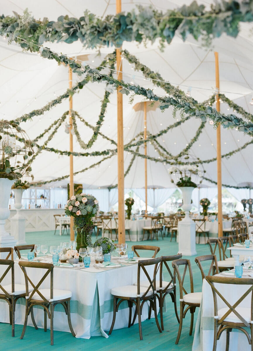 Ceiling Wedding Decor: Garlands of greenery hung all around a white tented reception.