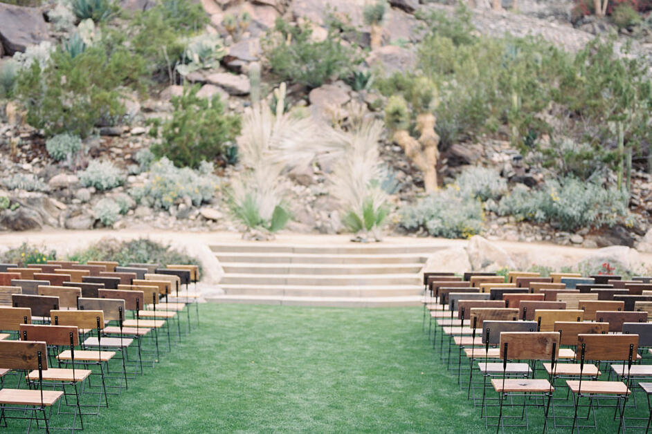 Celebrity Wedding: An outdoor ceremony setup in the desert with wooden chairs and a short staircase leading to the altar.