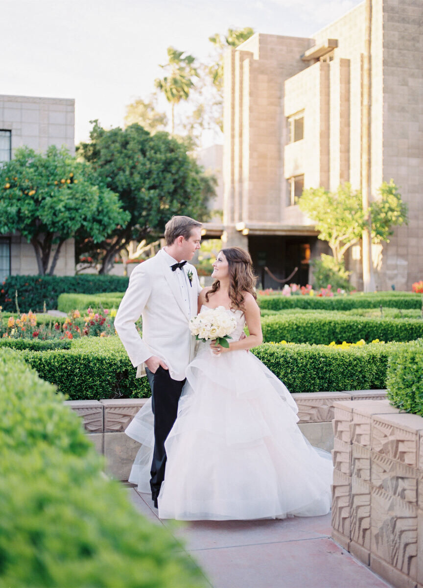 City Weddings: A bride and groom smiling at each other while posing at their wedding venue in Phoenix, Arizona.