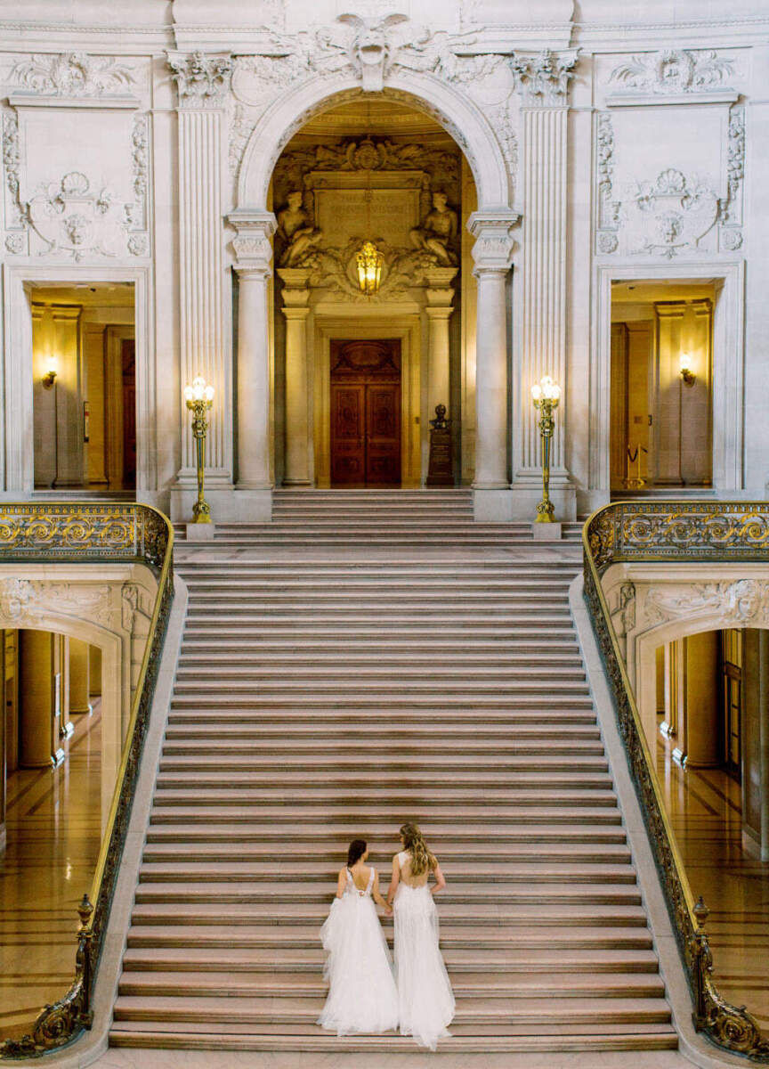 City Weddings: Two brides walking up a long staircase at San Francisco's City Hall.