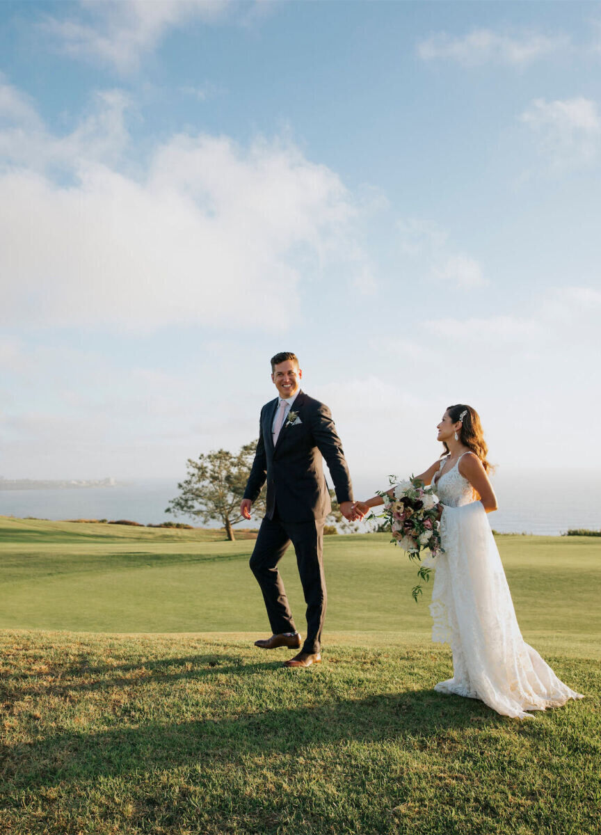 City Weddings: A groom and bride smiling and holding hands on a golf course near the ocean in San Diego, California.