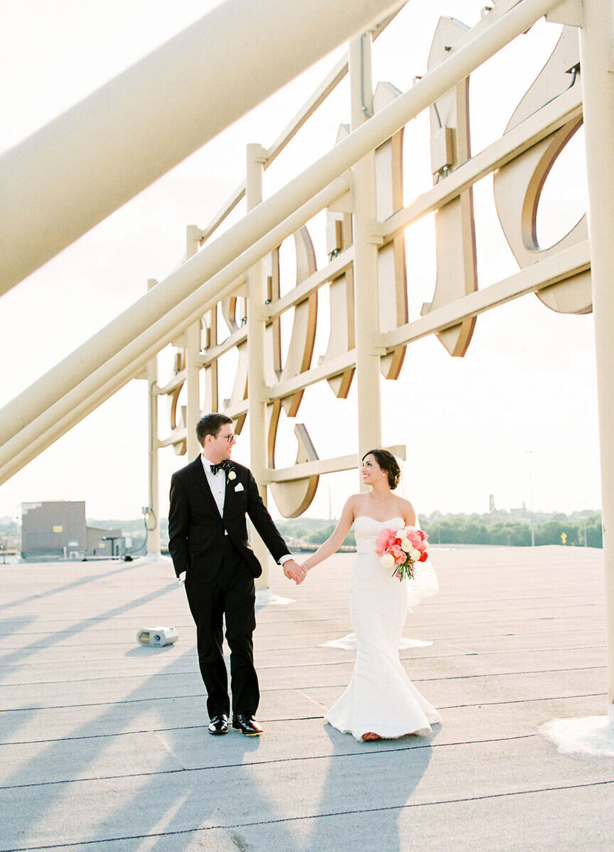City Weddings: A bride and groom holding hands and smiling at each other on a rooftop in St. Louis.