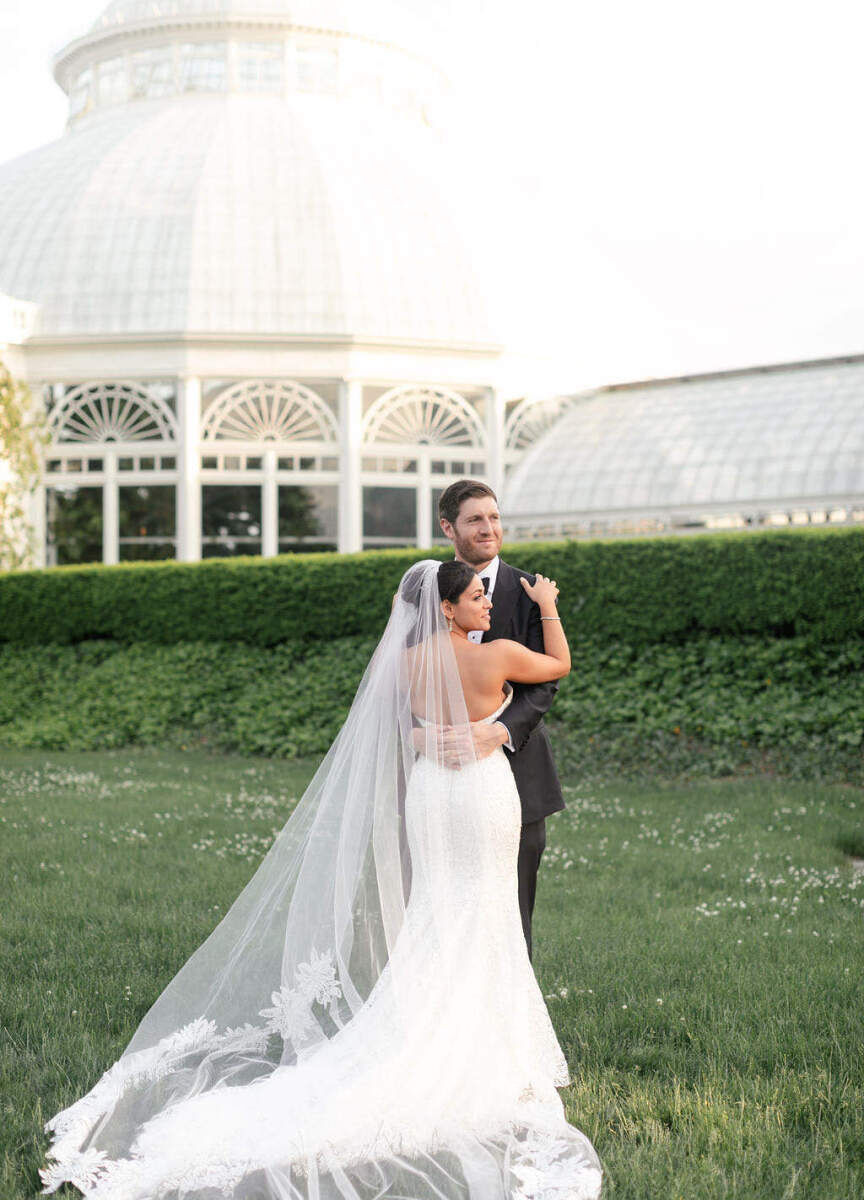 City Weddings: A wedding couple embracing outside of the New York Botanical Garden in the Bronx.