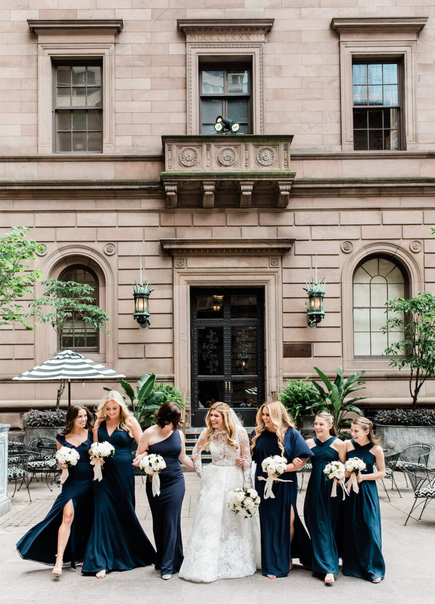 City Weddings: A bride with her bridesmaids, who are dressed in deep teal dresses outside the Lottle New York Palace.