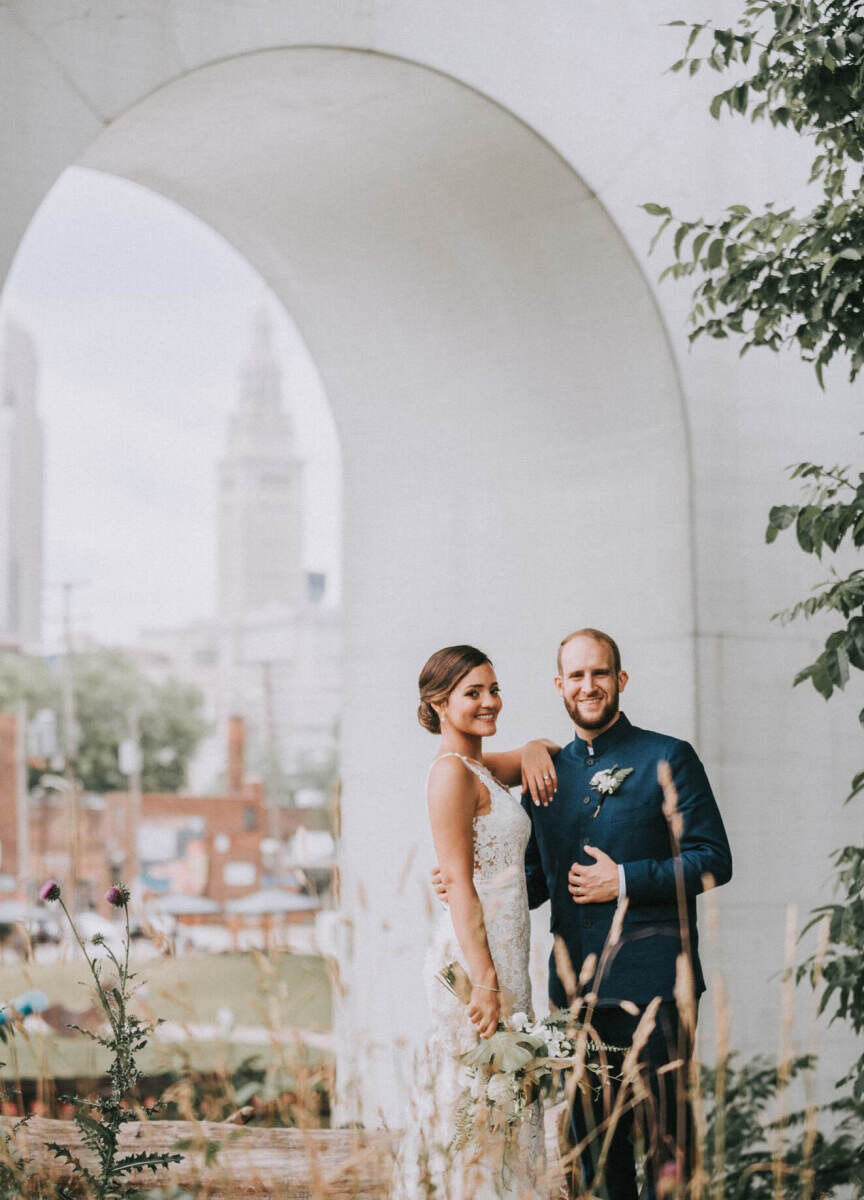 City Weddings: A wedding couple posing nearing a white arch in Cleveland, Ohio.