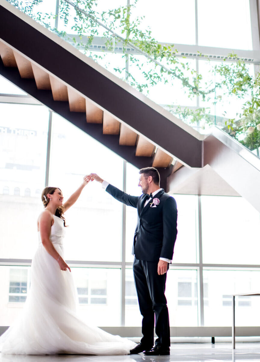 City Wedding: A groom twirling a bride near a staircase with accents of greenery in Cleveland.