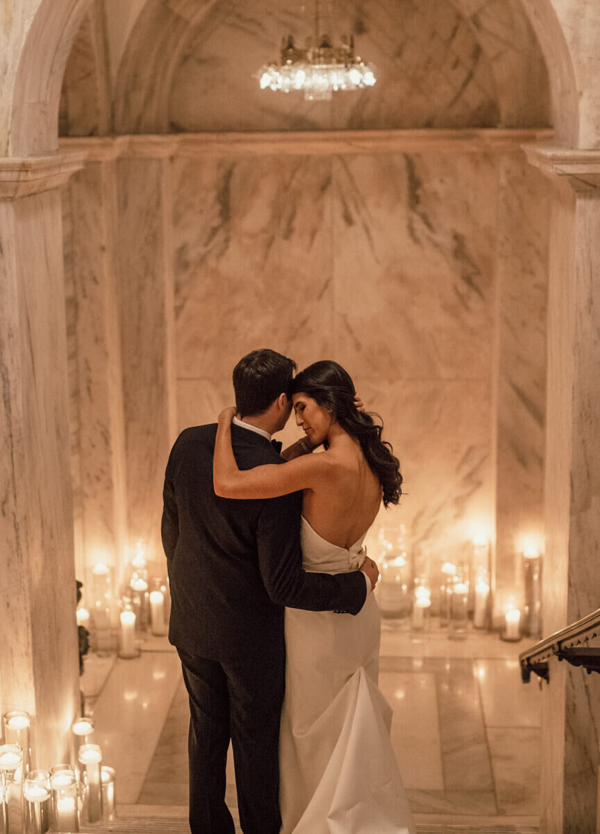 City Weddings: A wedding couple embracing on a candlelit marble staircase. 