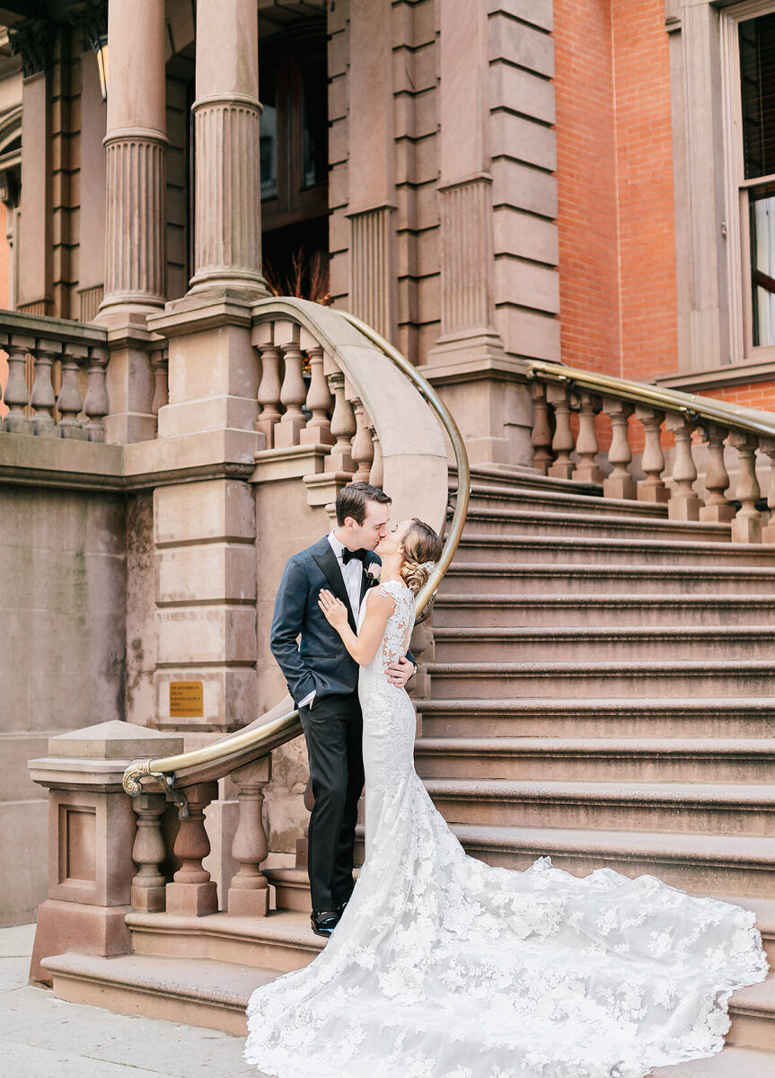 City Weddings: A wedding couple kissing on a staircase at The Union League of Philadelphia.
