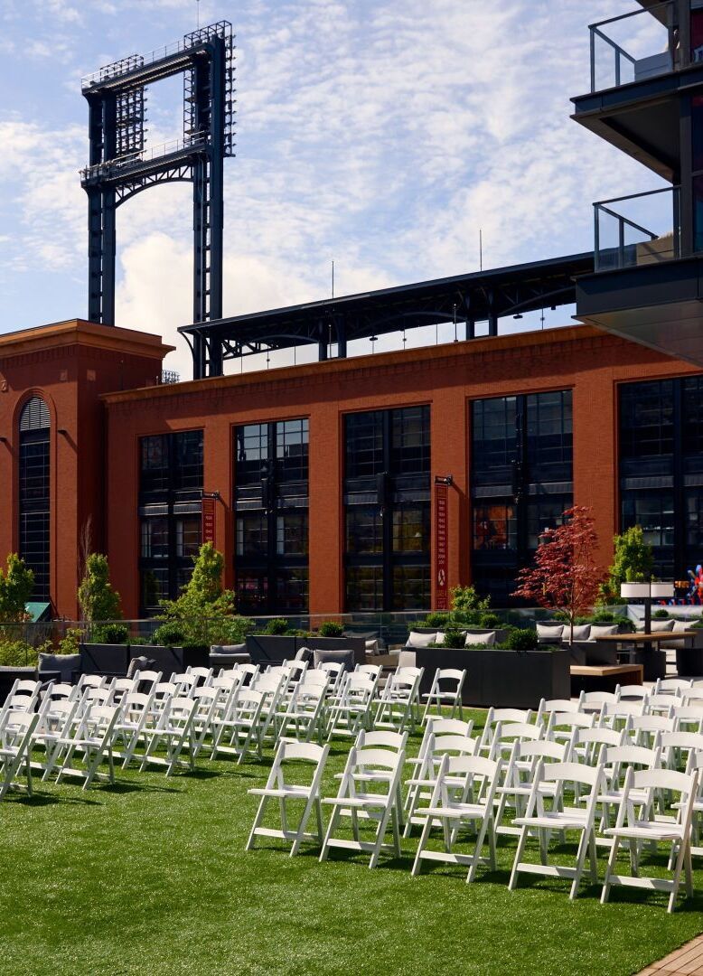 City Weddings: An outdoor ceremony setup with white chairs on a terrace at the Loews hotel in St. Louis.