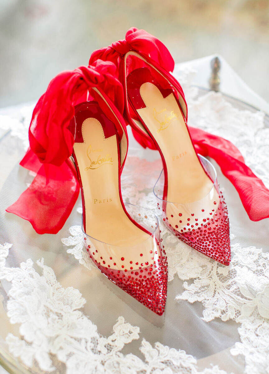 Red Christian Louboutin pumps and a traditional lace veil were worn during a colorful countryside wedding in England.