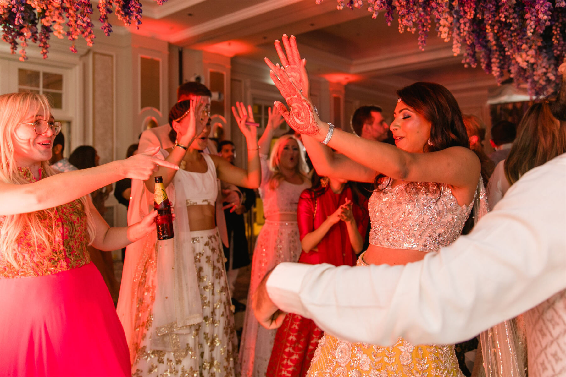 A bride and her friends dance during her colorful countryside wedding reception.