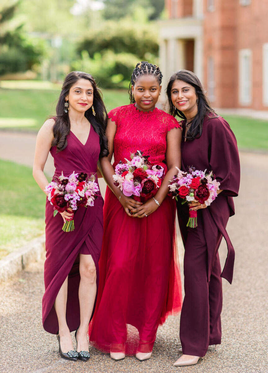 Bridesmaids wore shades of red for the civil ceremony of a colorful countryside wedding weekend in England.