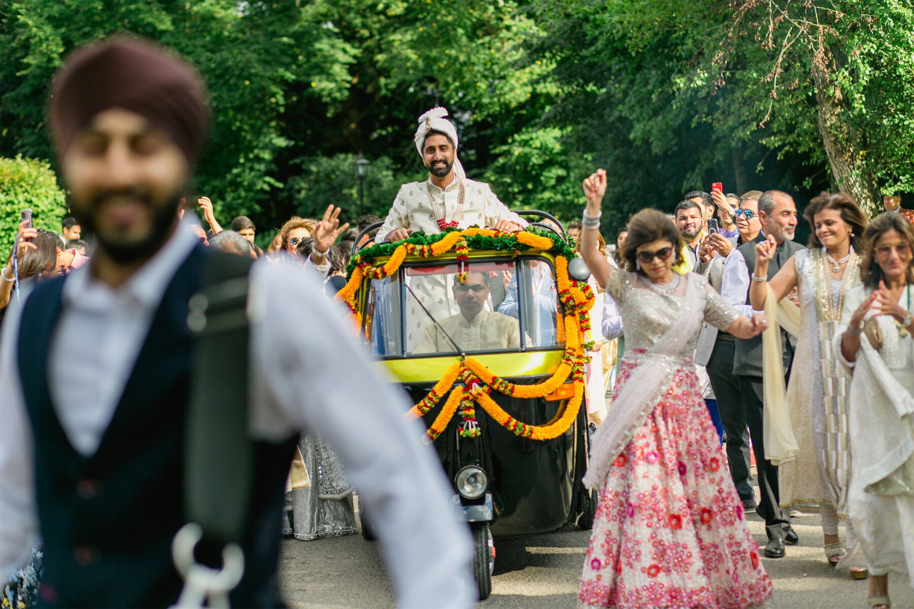 The groom arrives in a tuktuk during his baraat, starting the colorful countryside wedding ceremony.