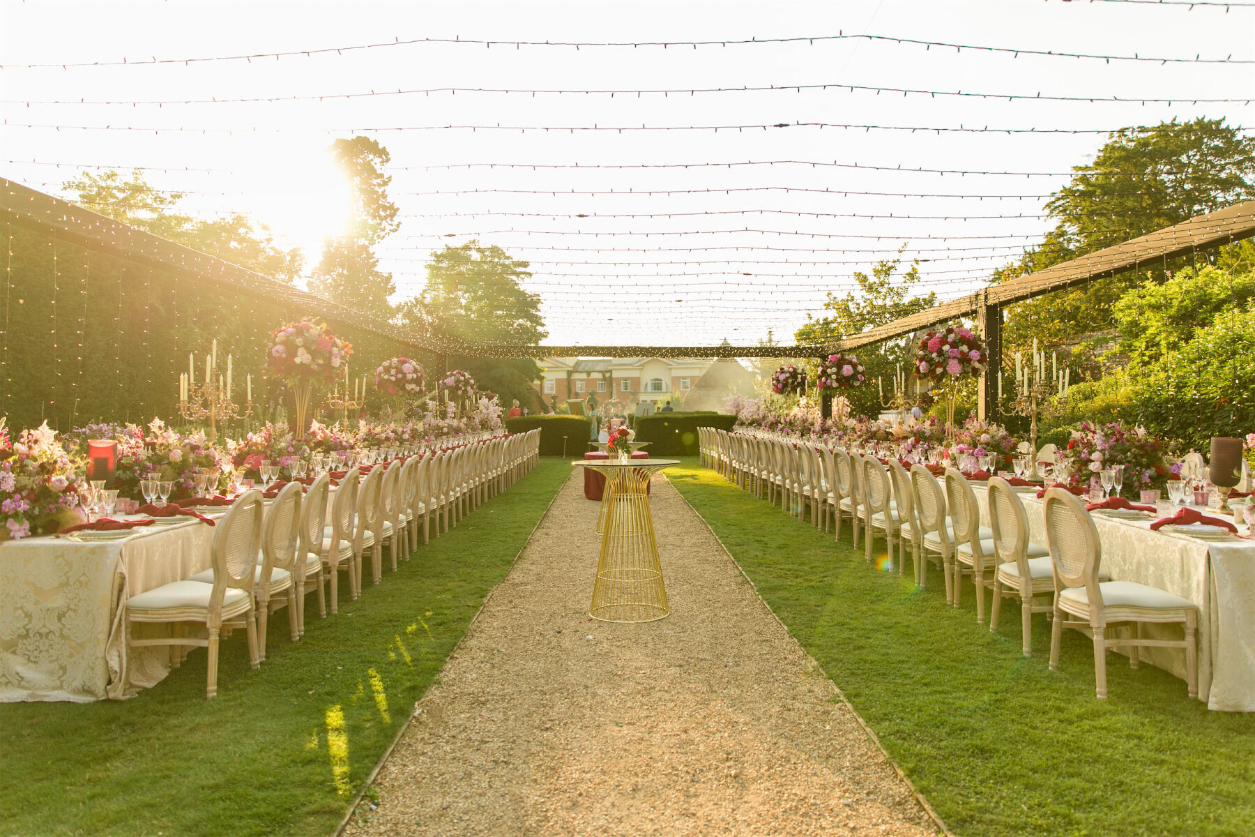 Two long tables set under string lights in the garden, were a romantic setting for a colorful countryside wedding.