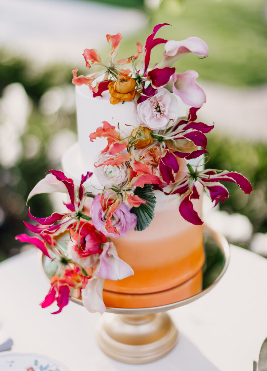 Colorful Wedding: A white and orange ombre wedding cake with pink and orange blooms.