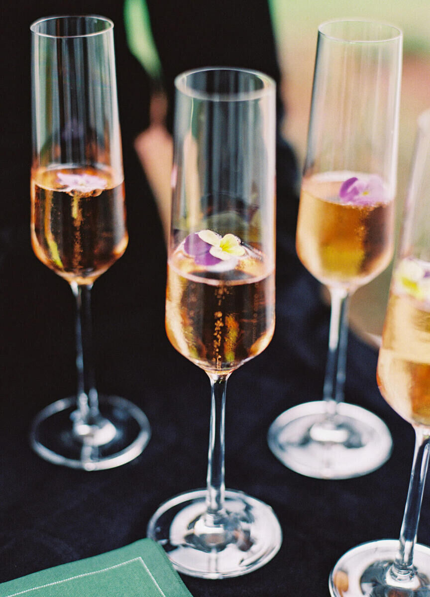 Flutes of bubbly with edible flowers inside each.
