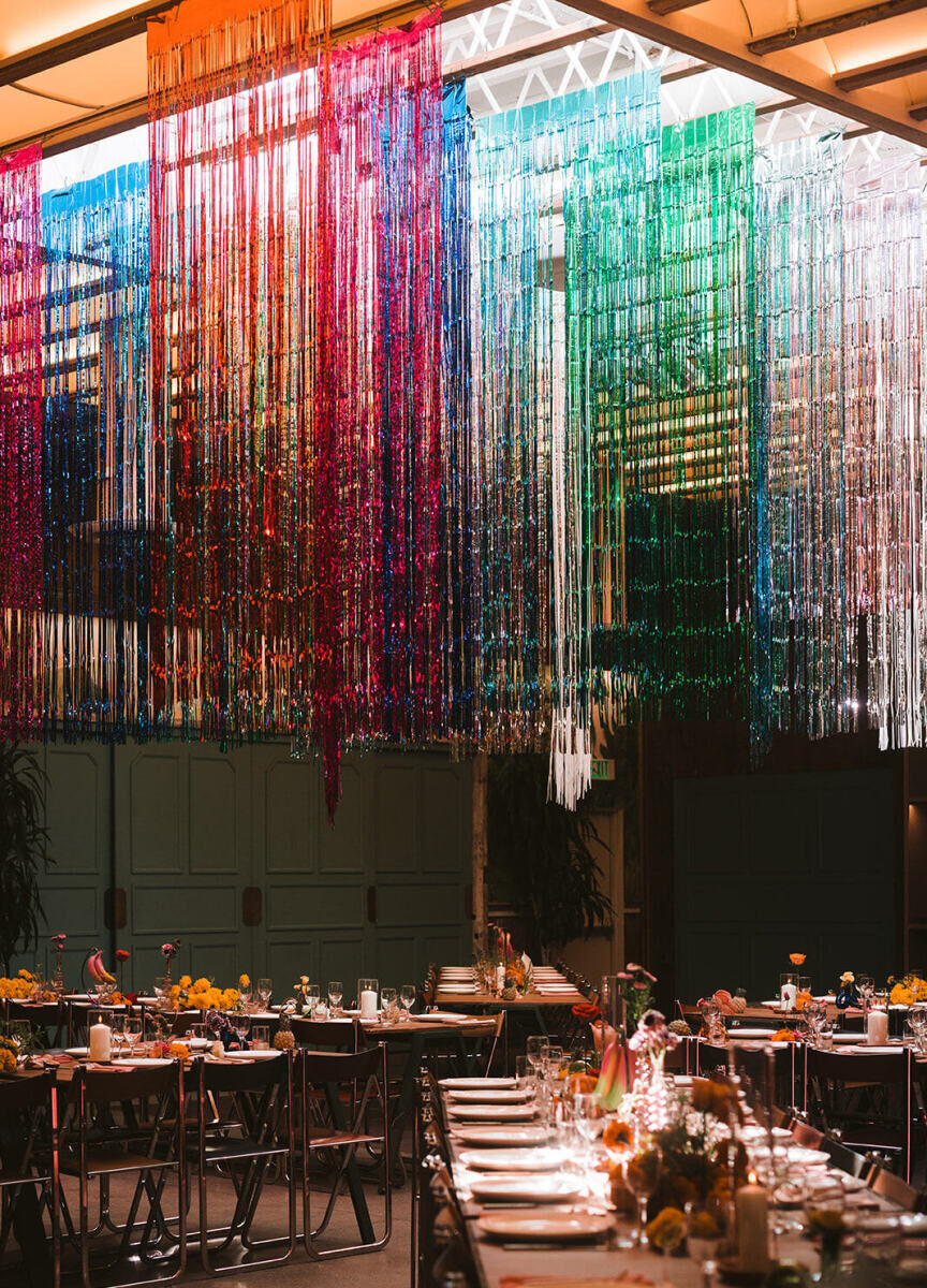 Best Places for a Colorful Wedding: A colorful indoor reception with rainbow streamers hanging from the ceiling at Valentine DTLA.