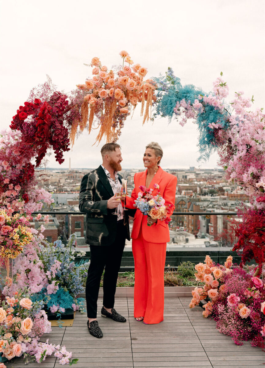 Best Places for a Colorful Wedding Venue: Two newlyweds standing under a colorful flower arch.