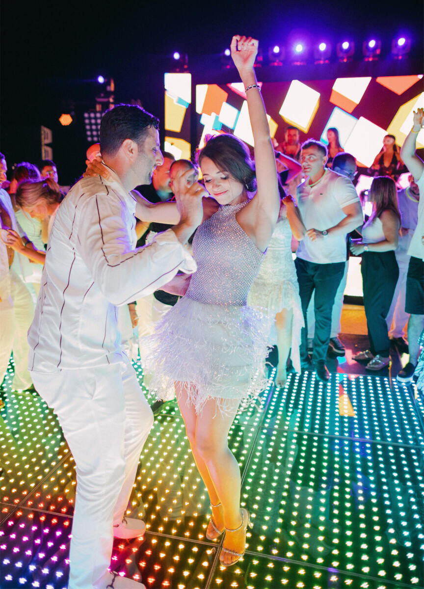 Best Places for a Colorful Wedding: A couple happily dancing on a brightly lit neon dance floor at Grand Velas Riviera Maya.