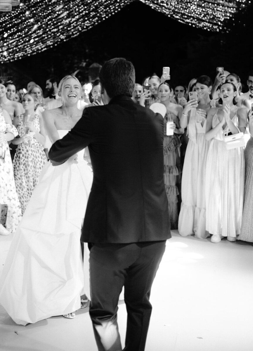 Newlyweds dance during their destination wedding reception under a canopy of lights.