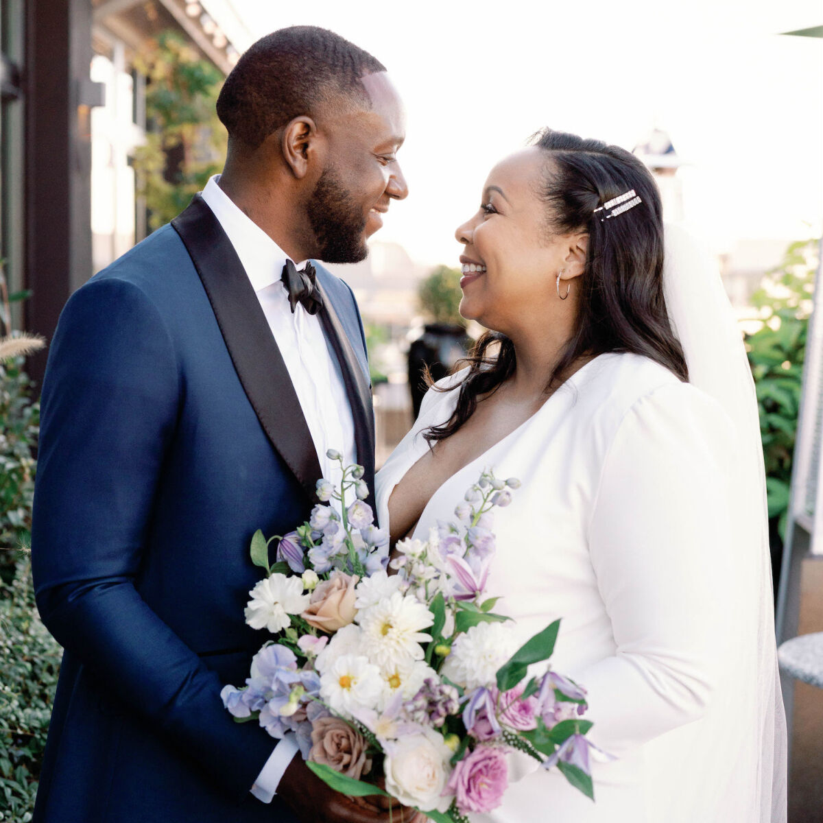 A smiling groom and bride look at each other at their DC elopement wedding.