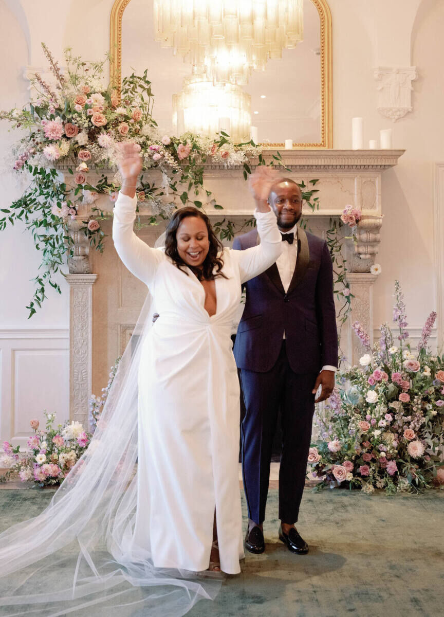 A bride raises her arms in joy after making it official at her elopement wedding.