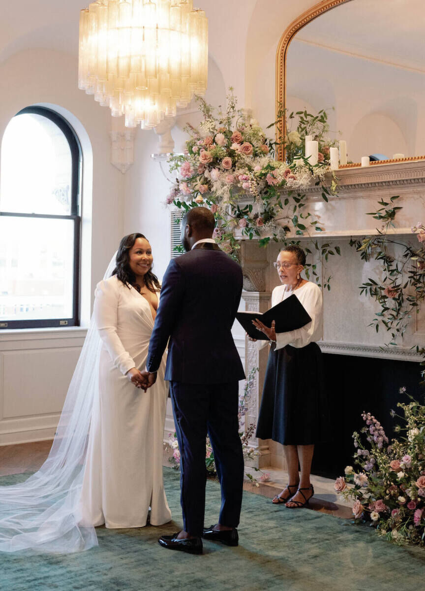 A bride and groom get married in the suite of a hotel during their elopement wedding.