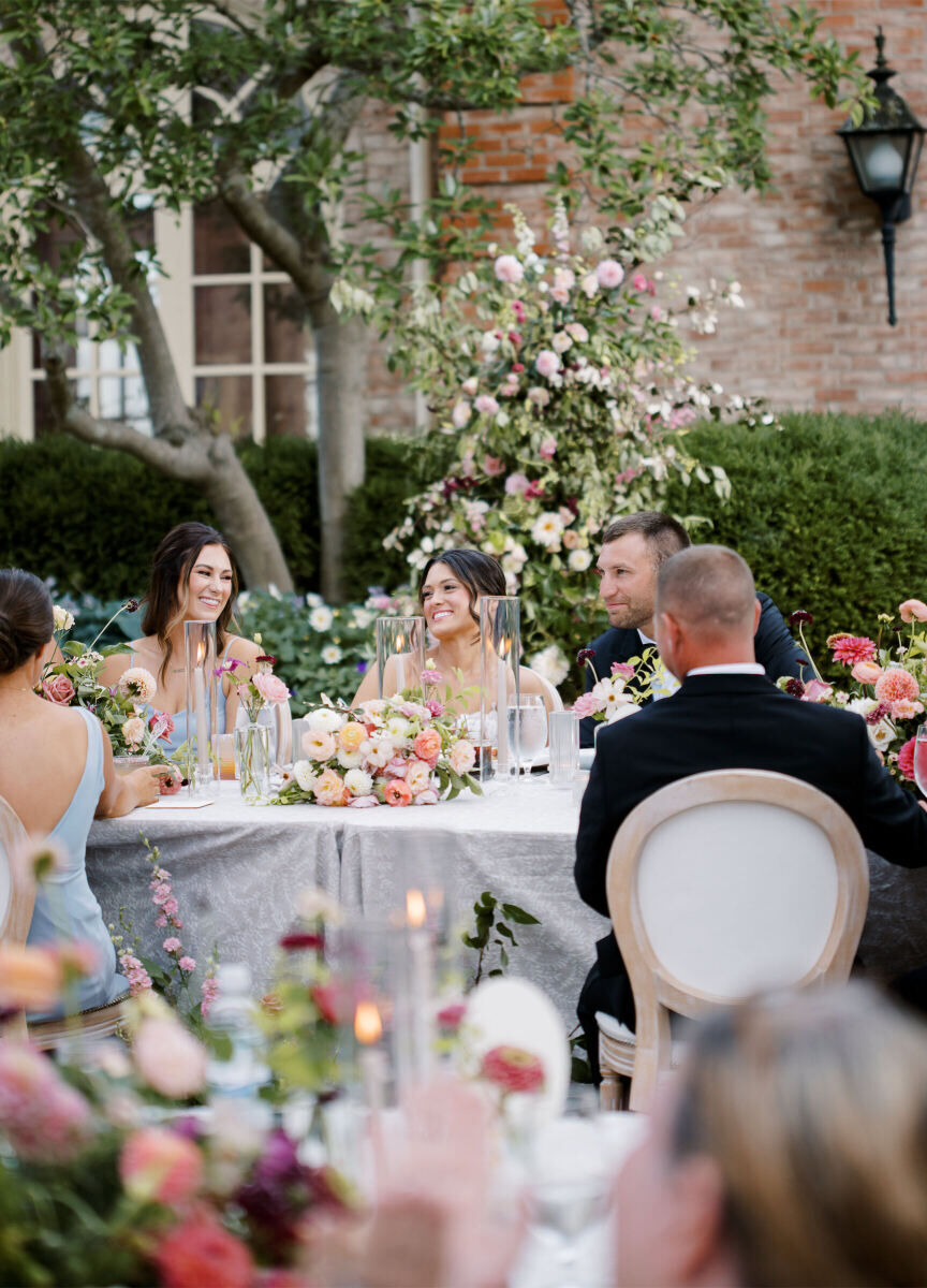 A newlywed couple and their guests enjoy an al fresco reception at this enchanted garden wedding.
