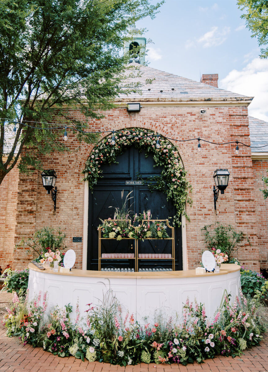 A flower-lined bar during an enchanted garden wedding cocktail hour.