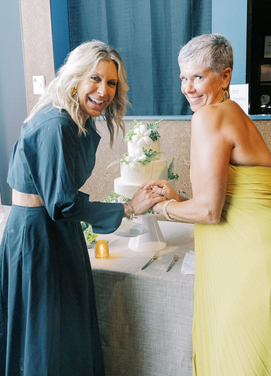 Since the bride and groom aren't big fans of cake, the bride's mom and her friend cut into the cake at their enchanted waterfront wedding.