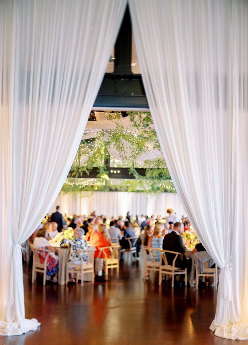 Drapery softened the event space where dinner took place at an enchanted waterfront wedding, and later was pulled back to reveal an after-party room.